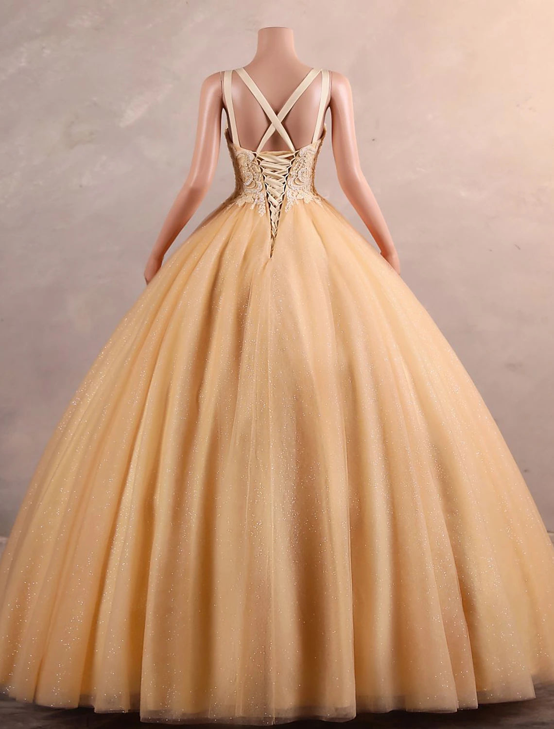 Close-up of sequin appliques on the tulle fabric of the dress.