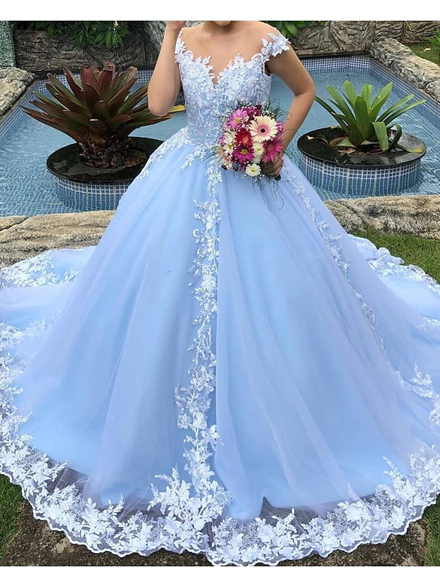 Close-up of intricate lace and applique details on a wedding dress.