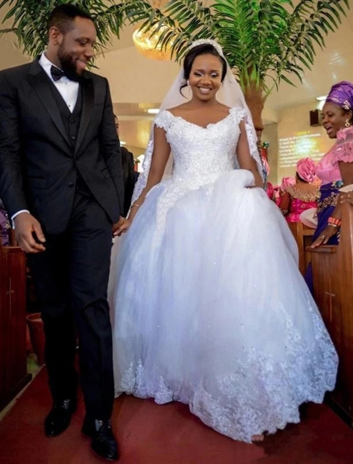 Back view of a formal bridal gown showcasing the chapel train and intricate lace details.