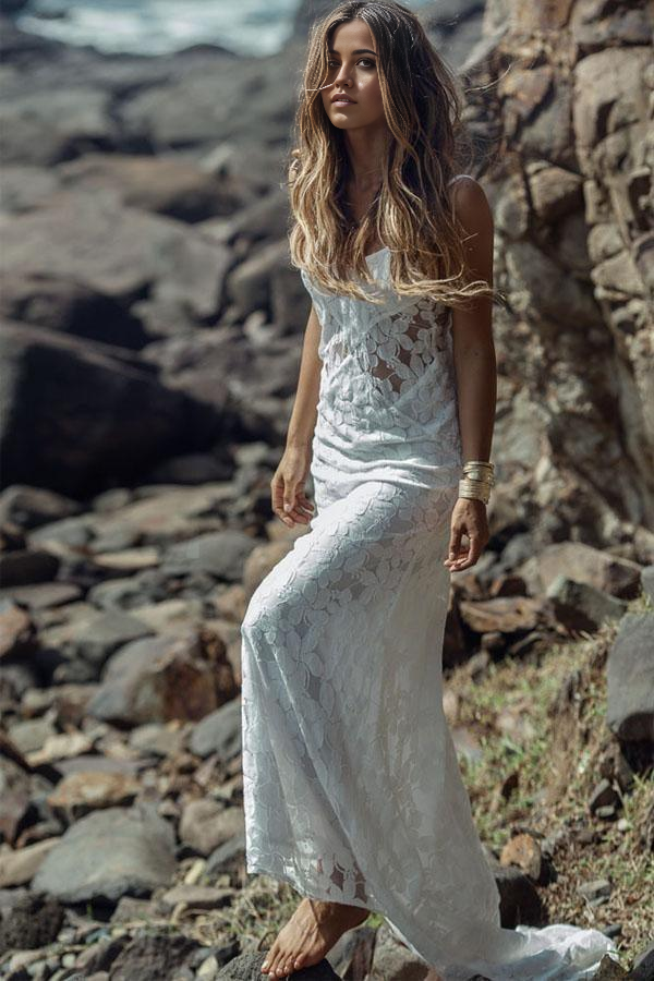 Elegant beach wedding dress with spaghetti straps and lace details.