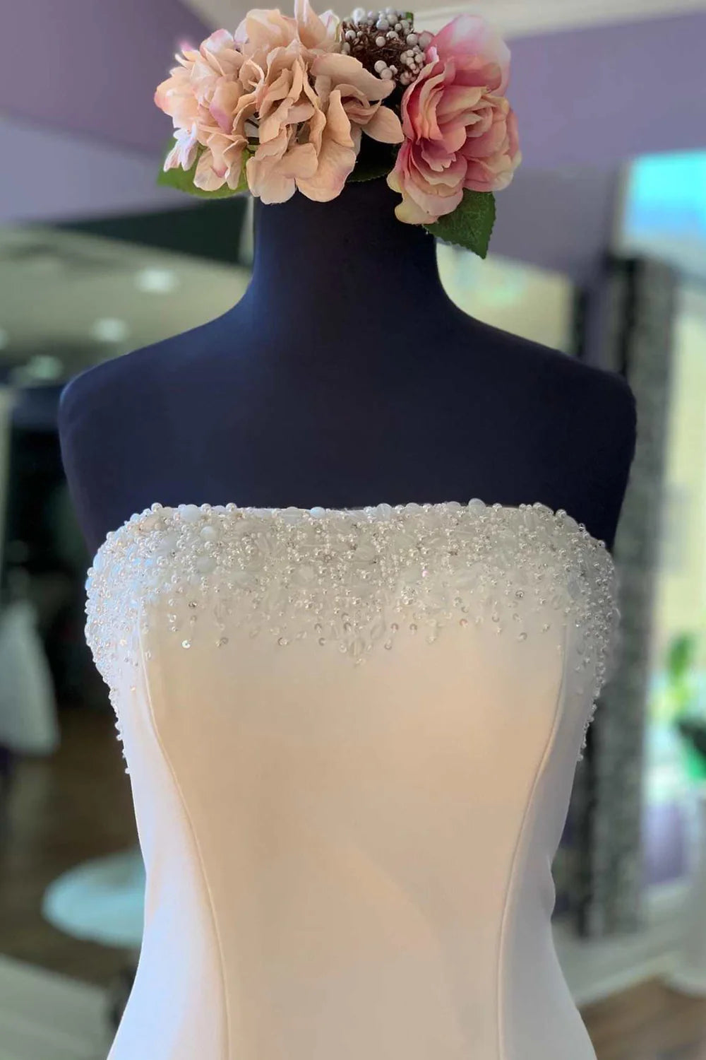 Side view of a beaded strapless mermaid wedding dress.