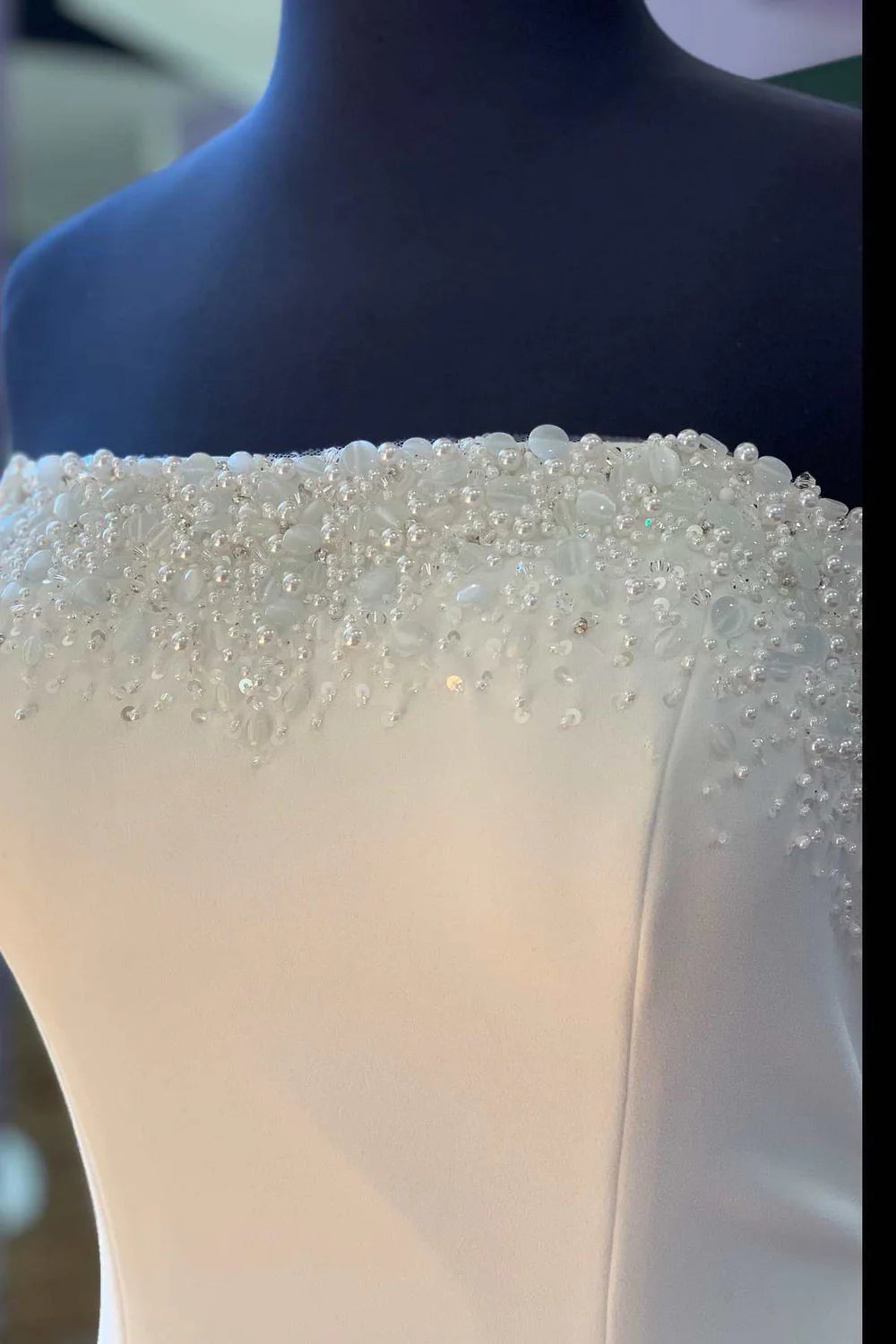 Back view of a long white bridal gown with mermaid silhouette.