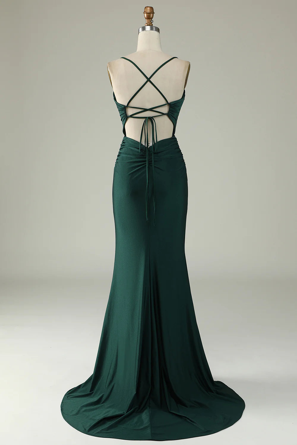 Woman in a dark green beaded mermaid V-neck long prom dress, side view.