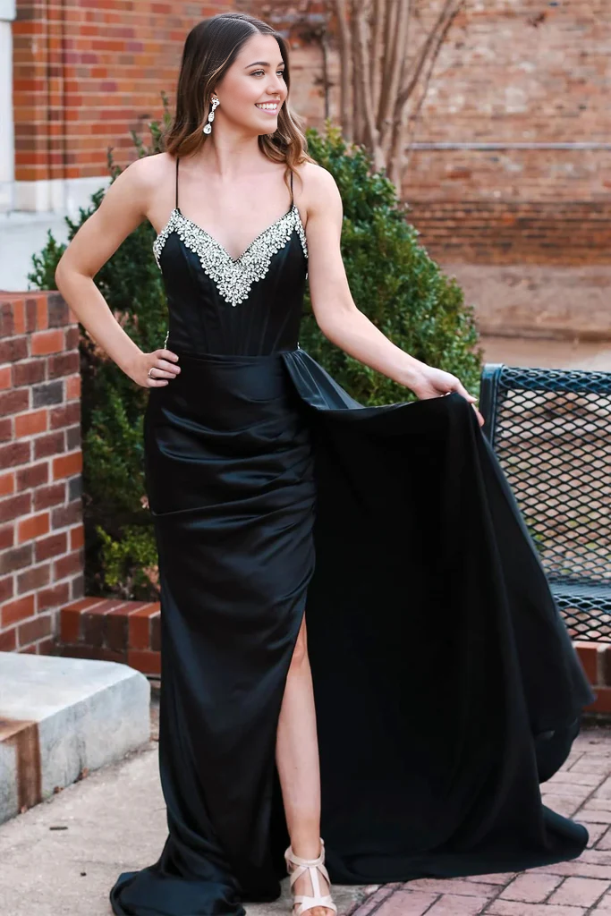 Back view of a woman wearing a mermaid prom dress with an attached train.