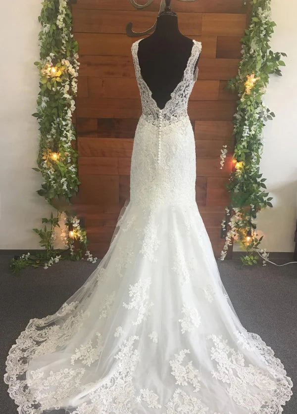 Back view of a white beaded V-neck wedding dress with train.
