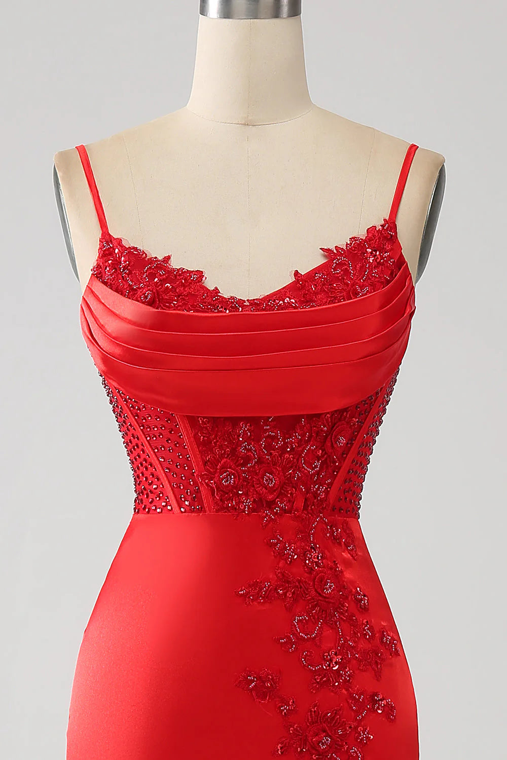 Close-up of the beaded detail on a red mermaid prom dress.