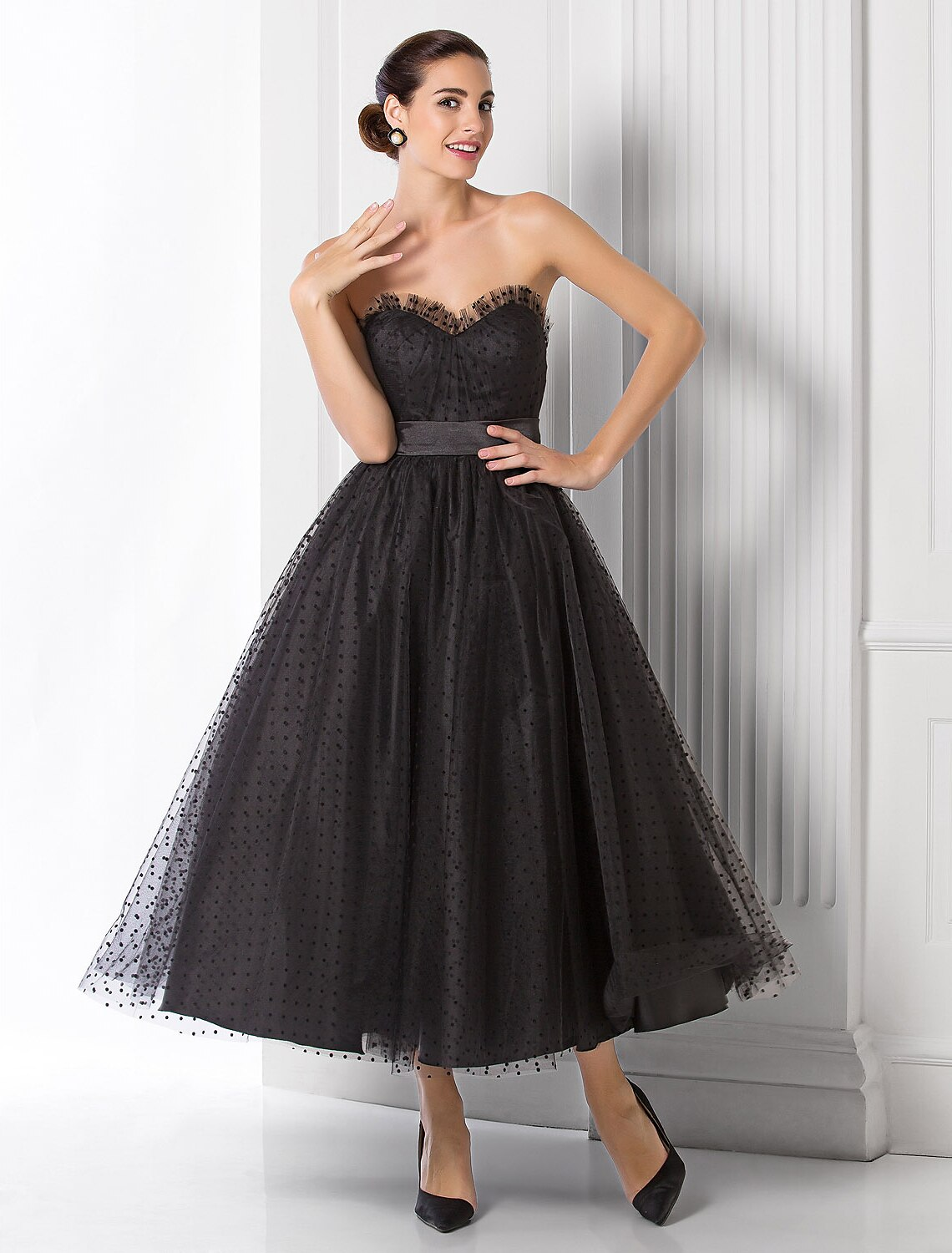 Side view of the black ball gown, highlighting the flowing tulle skirt and waist sash.
