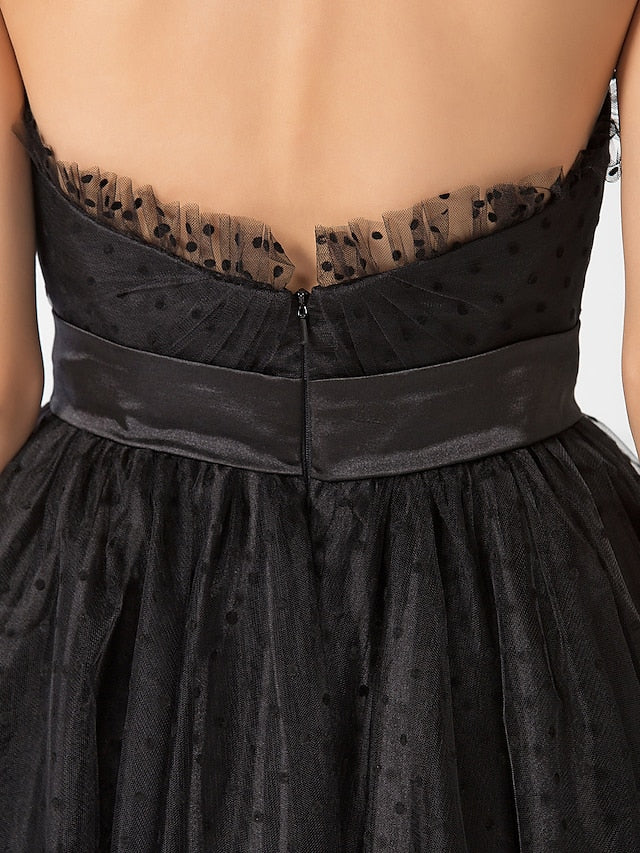 Back view of the black tea length dress, showcasing the sash detail.