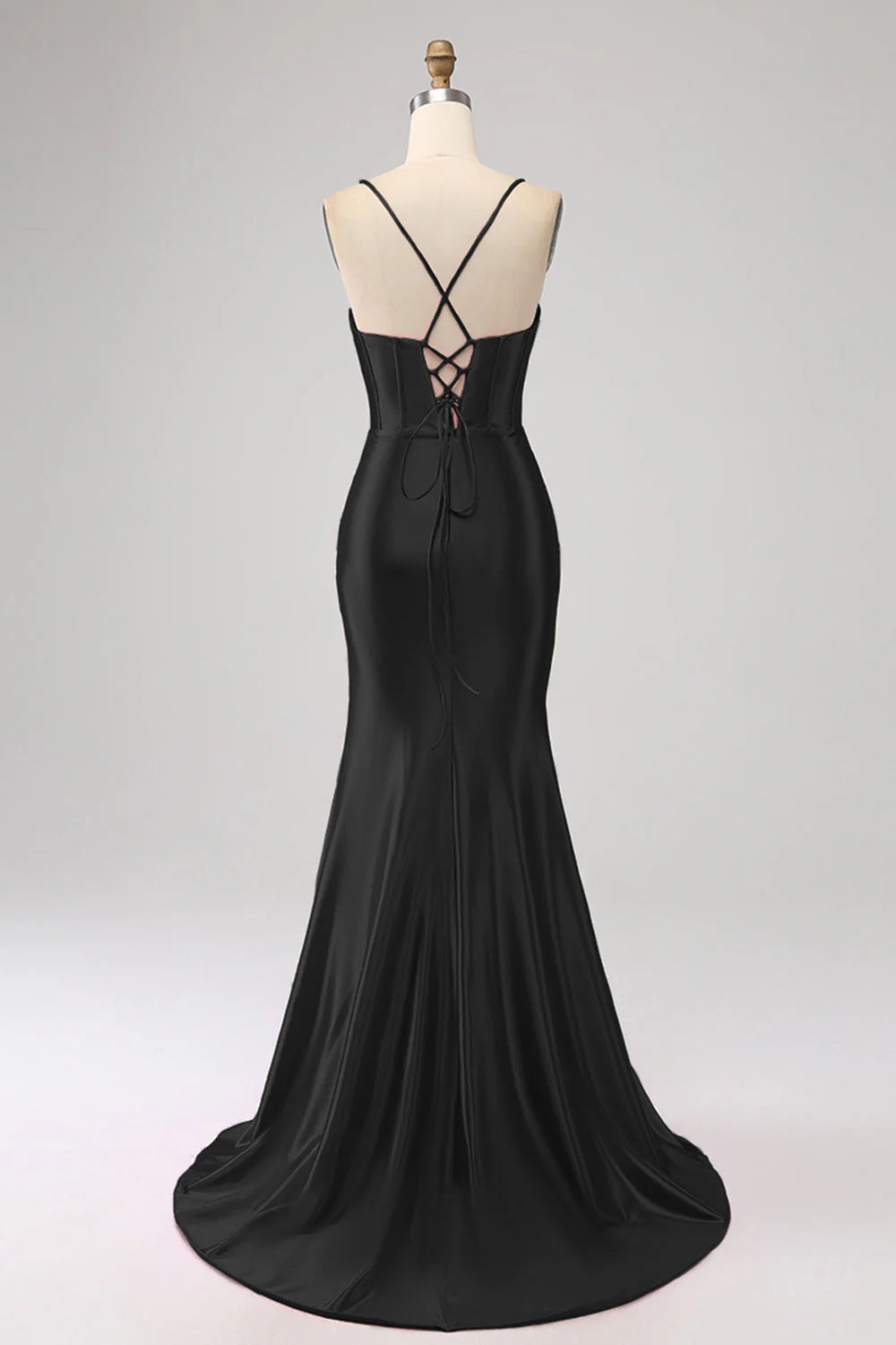 Model wearing a black mermaid prom dress with spaghetti straps.