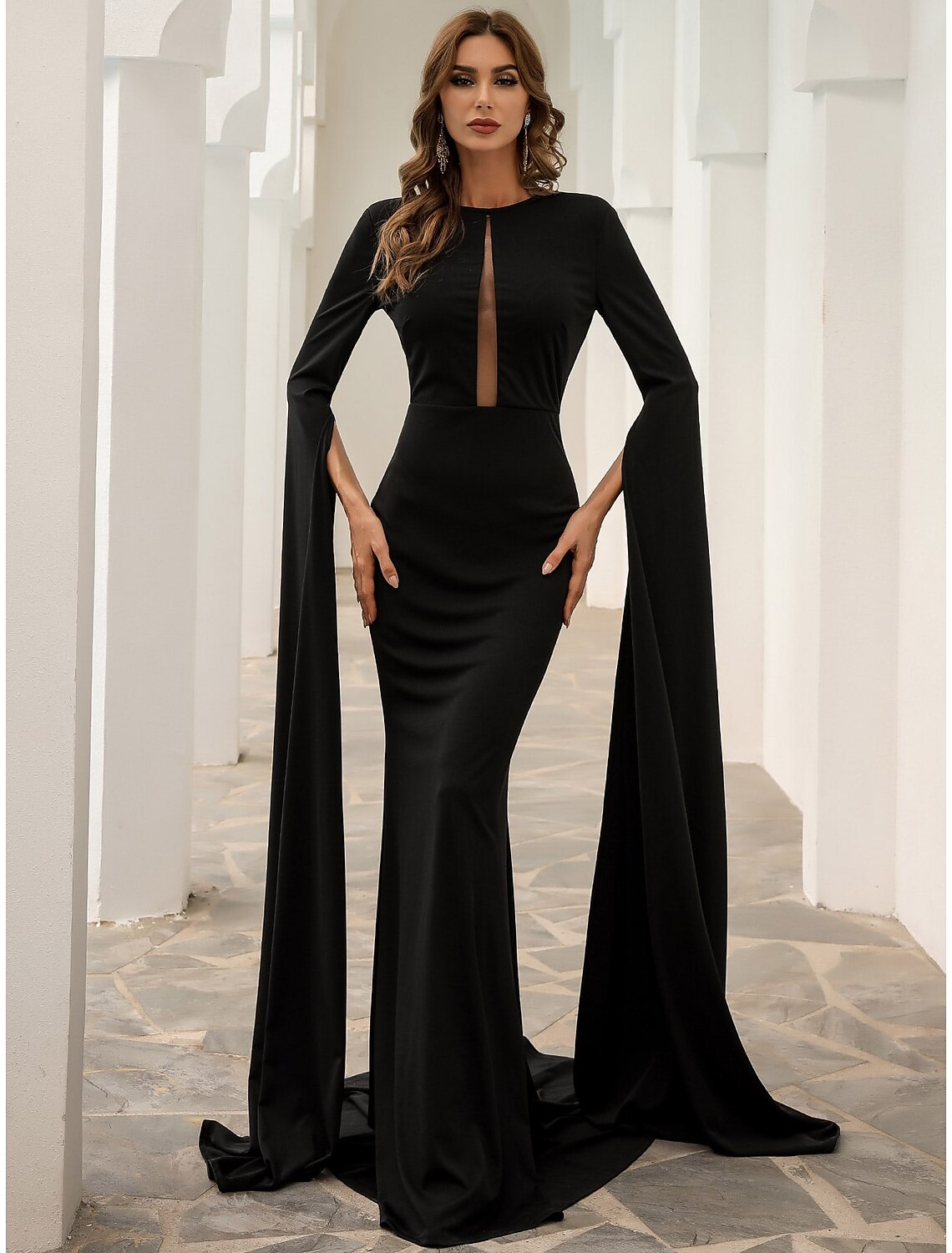 Model wearing a black mermaid evening gown with long sleeves and a jewel neck.