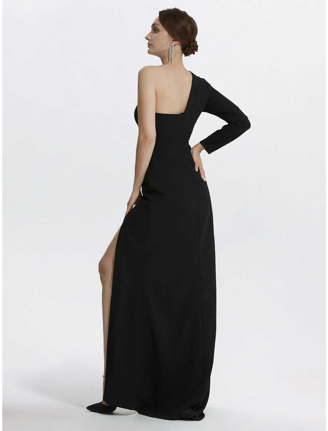 Model posing gracefully in the black mermaid one-shoulder long-sleeve gown, side view.