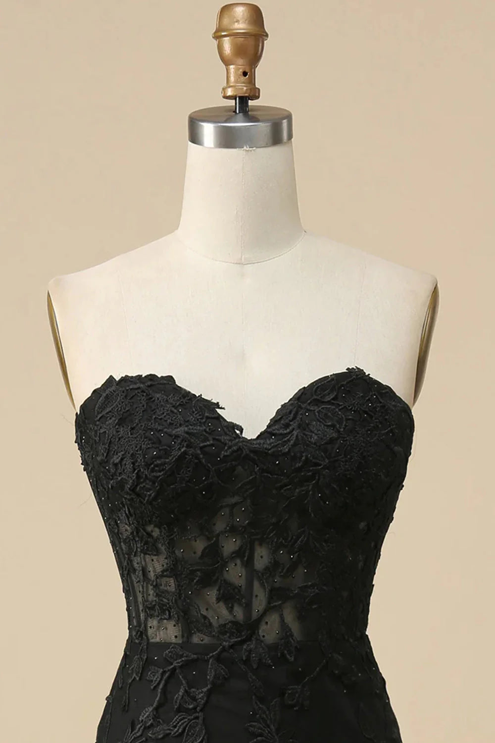Close-up of the sweetheart corset bodice and lace embellishments on the black dress.