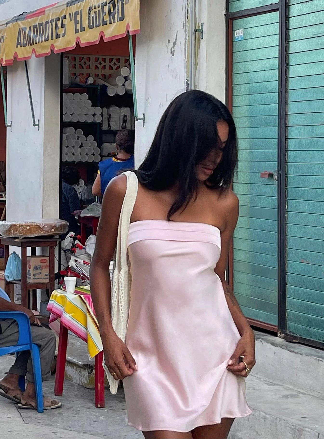 Model wearing a blush pink strapless satin mini dress with an open cowl back.