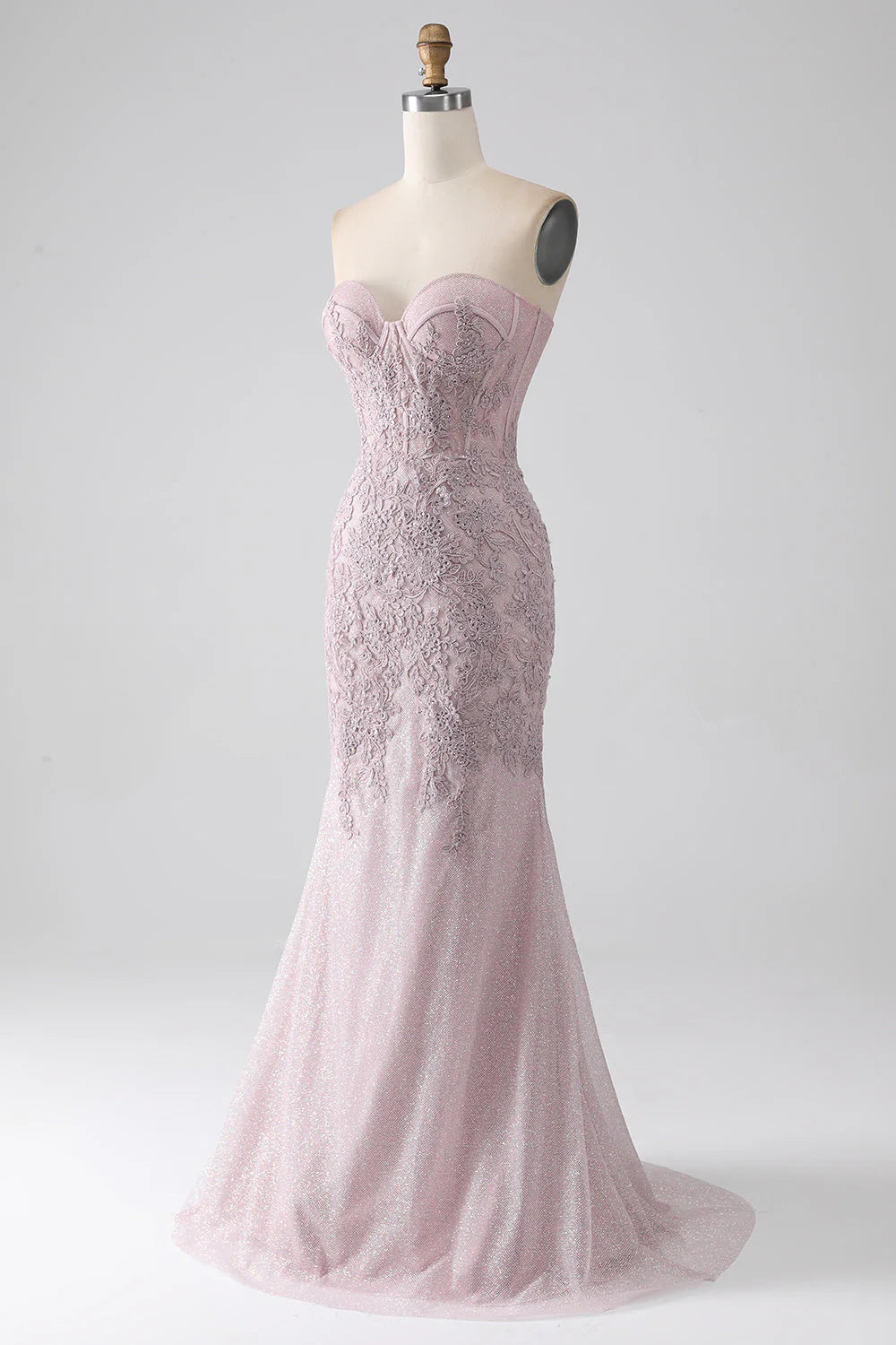 Close-up of appliques on a blush mermaid prom dress.