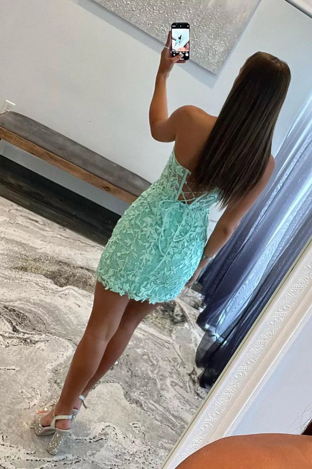 Side view of model in a blue bodycon sweetheart corset dress with appliques.