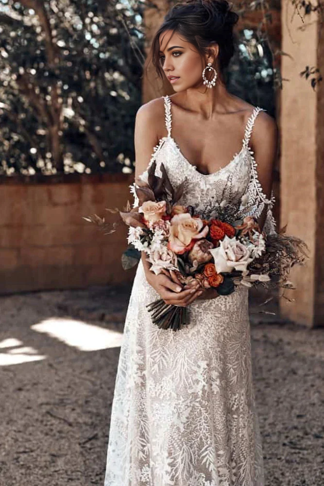 Woman wearing an ivory bohemian mermaid wedding dress with a scoop neckline.