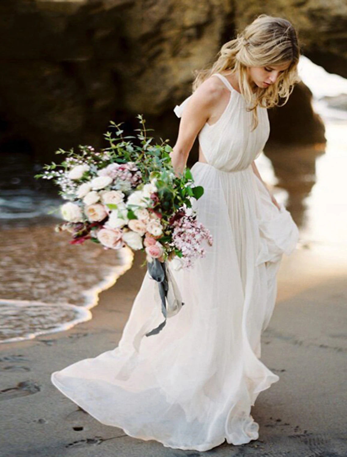Model wearing a Boho A-Line halter wedding dress with a sweep train.