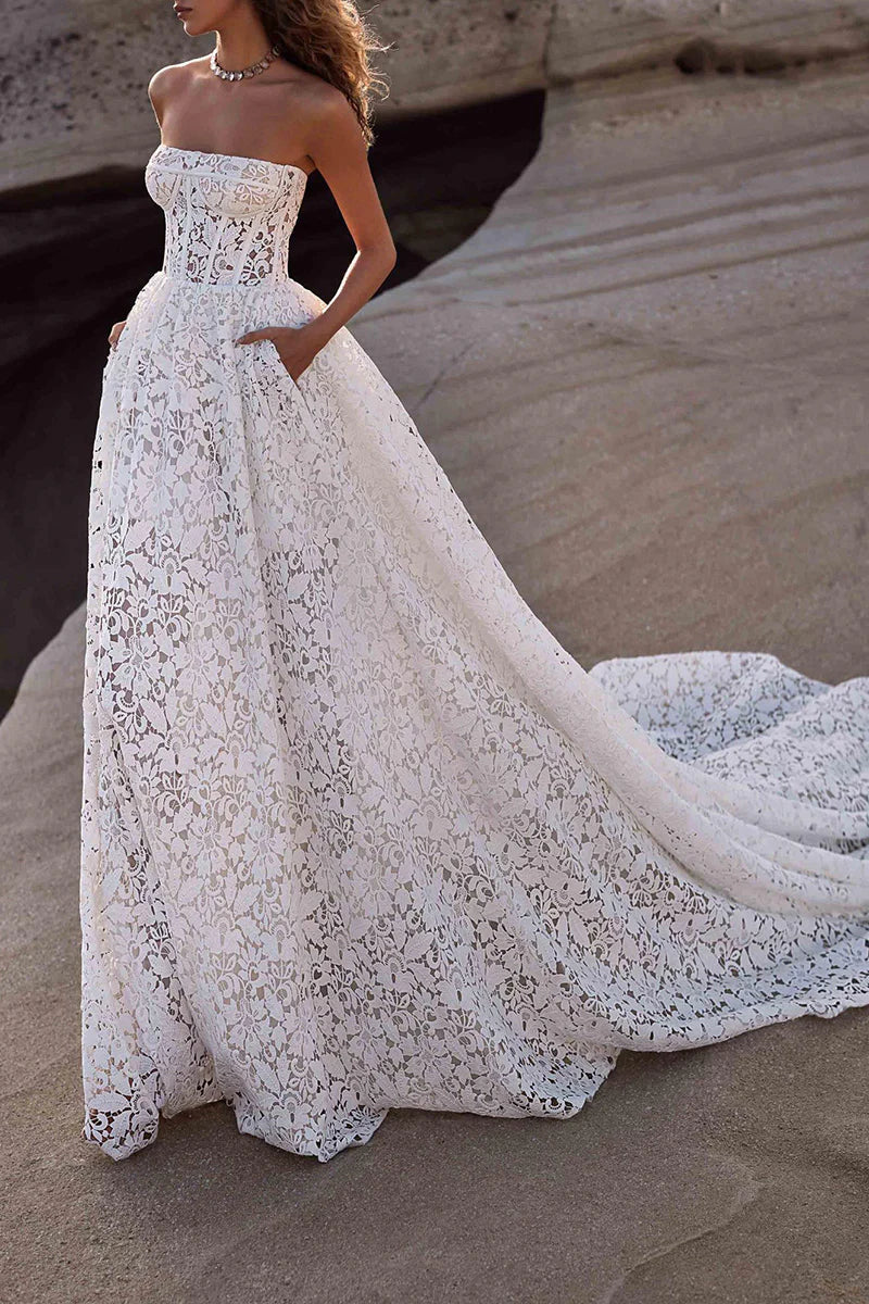 Back view of a bride wearing a strapless lace A-line wedding gown.