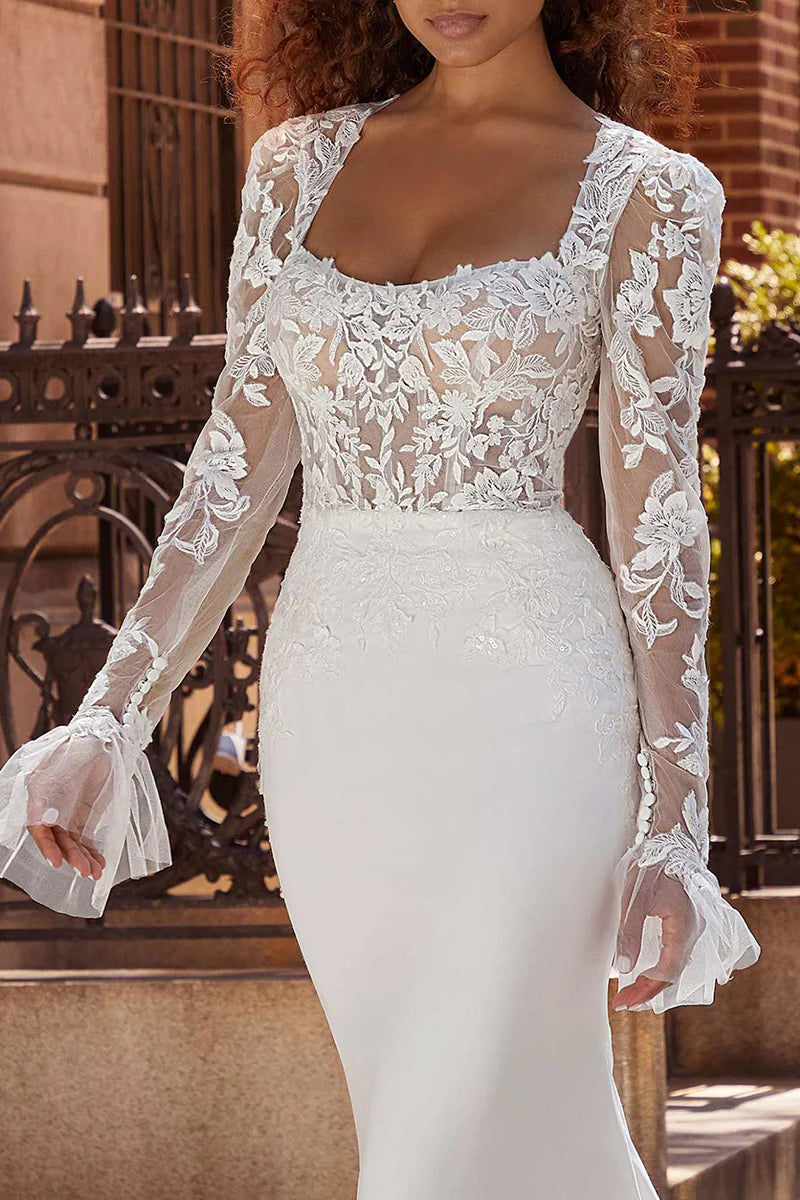 Close-up of the square neckline and long sleeves on a wedding dress.