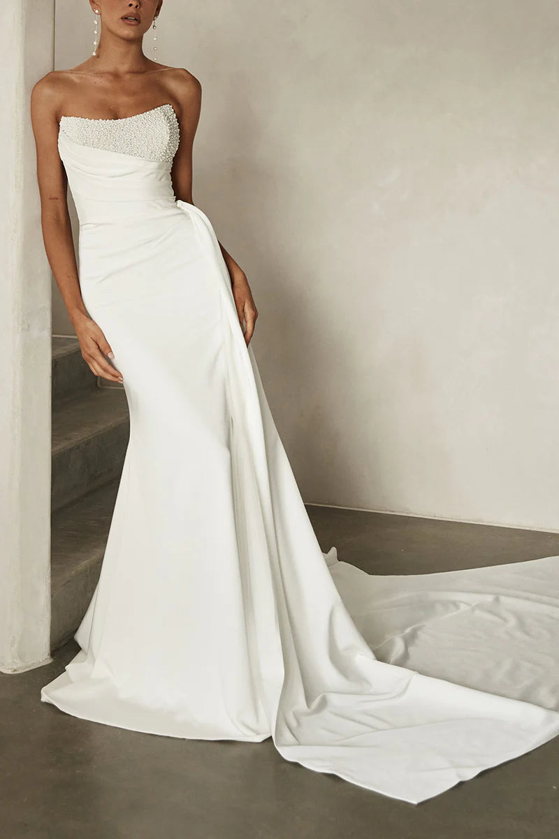 Woman wearing an elegant Boho strapless V-neck satin wedding dress with bead details, front view.