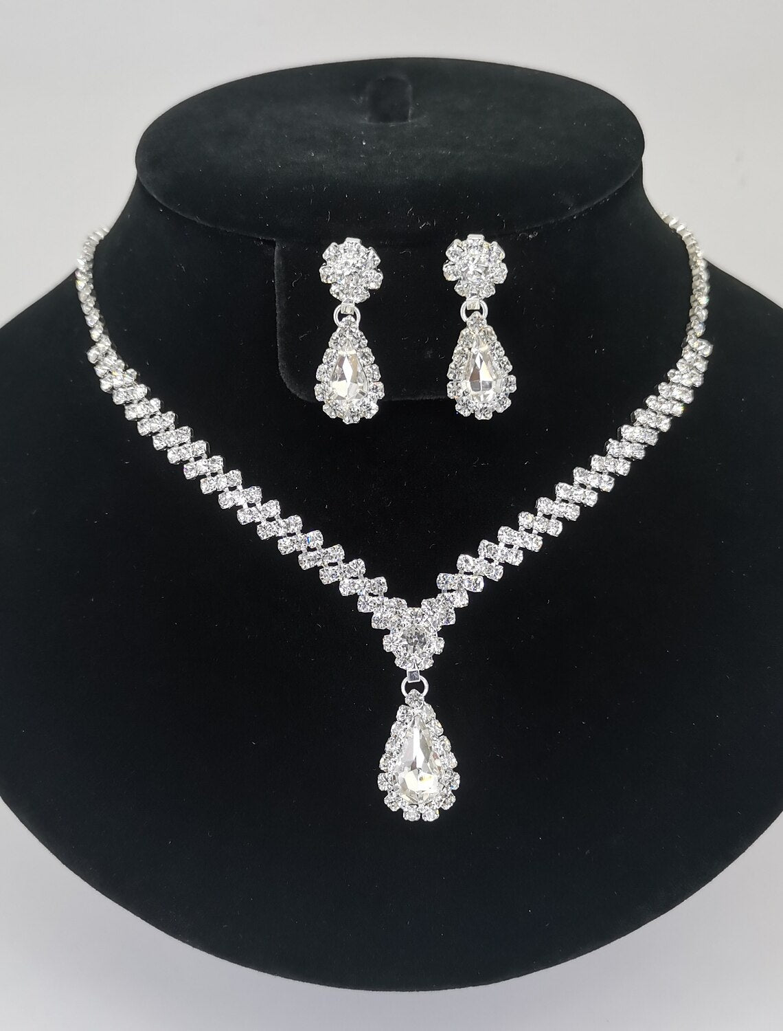 Woman wearing an elegant bridal jewelry set with briolette drop necklace and matching earrings.