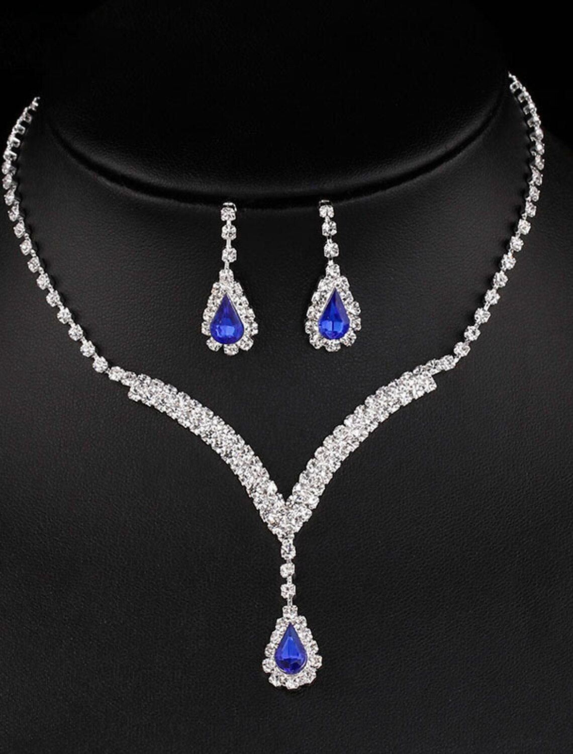 Woman wearing an elegant bridal rhinestone necklace and matching earrings set.