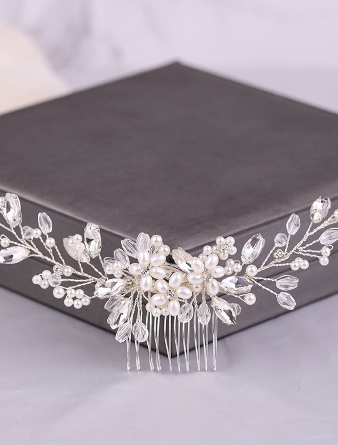 Close-up of a bridal hair comb showcasing intricate faux pearl and rhinestone details.