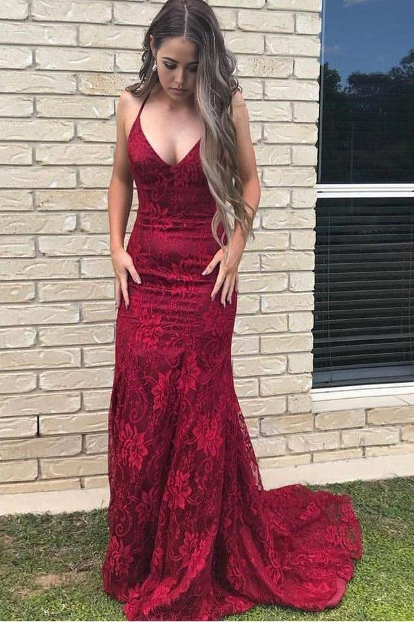 Model wearing a burgundy mermaid prom dress with spaghetti straps and lace back.