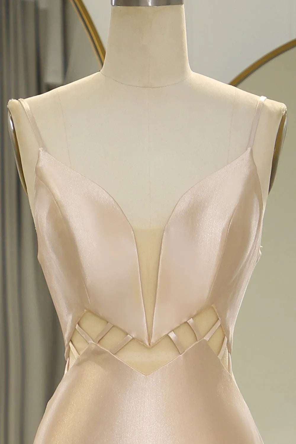 Close-up of the satin fabric and spaghetti straps on the Champagne prom dress.