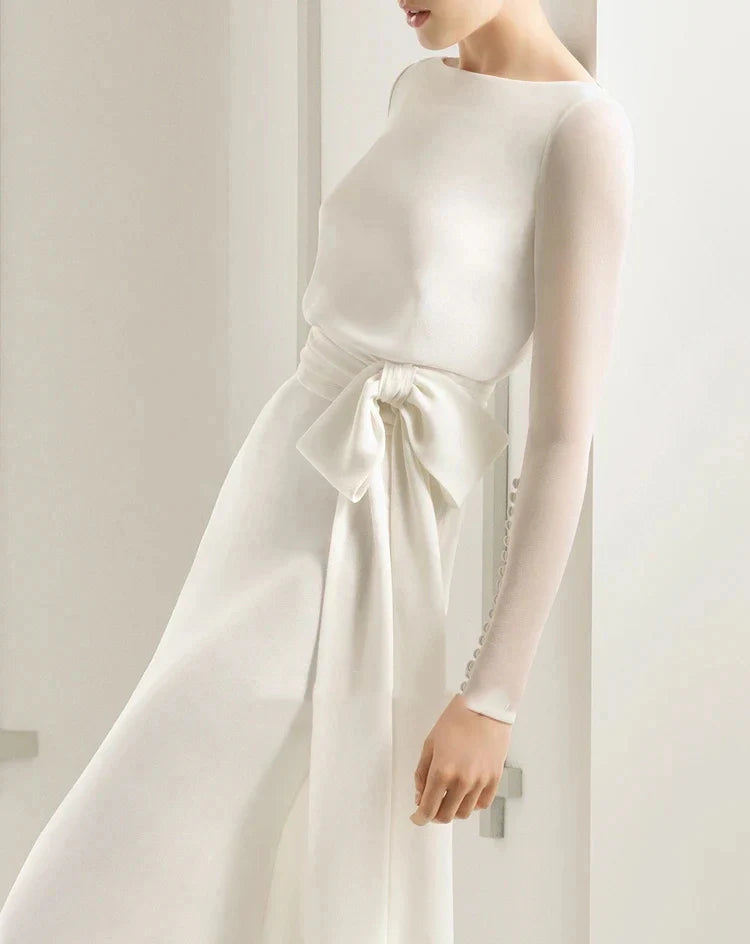Close-up of the chiffon long sleeve wedding dress showing decorative buttons and bow detail.