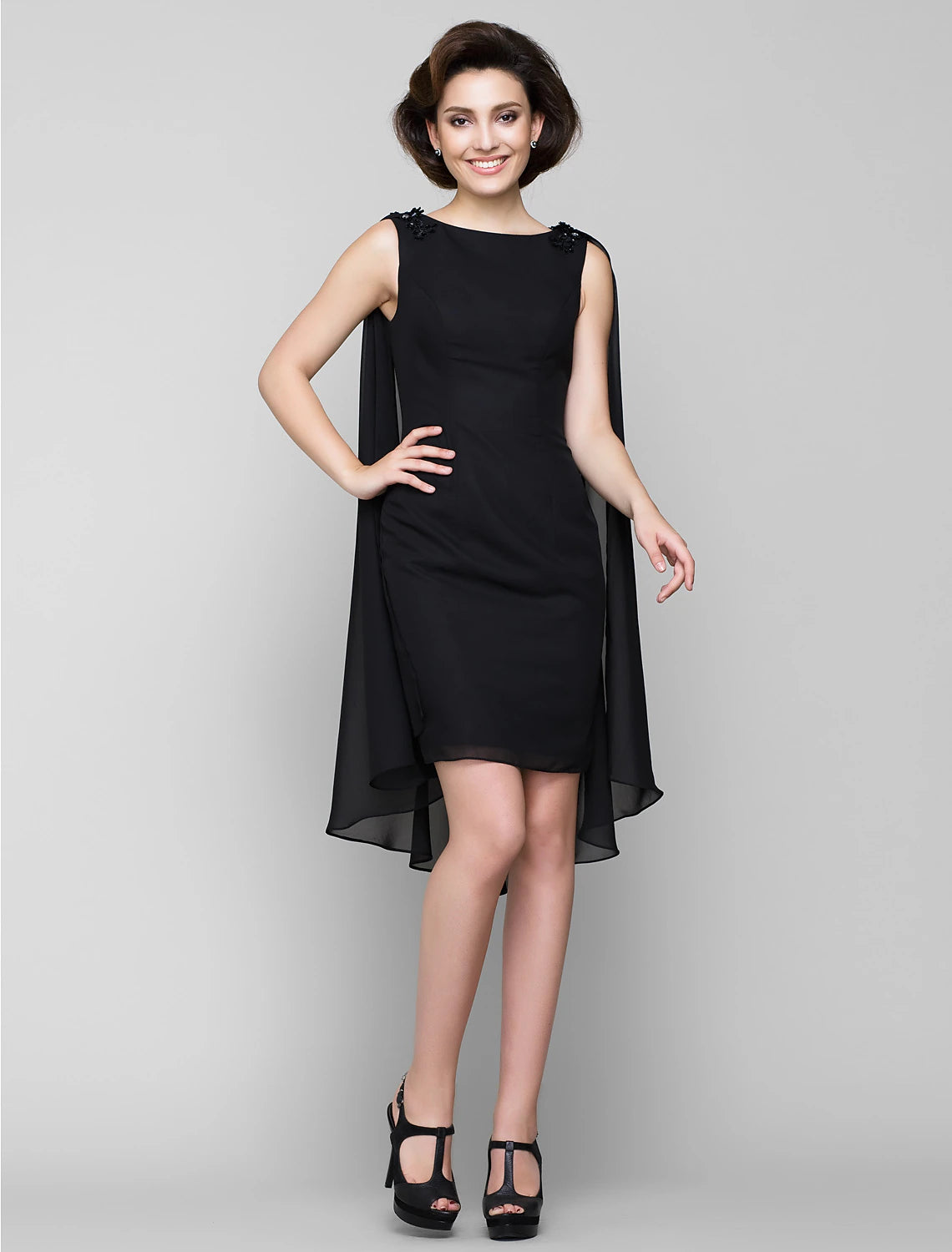 Woman in elegant knee-length chiffon Mother of the Bride dress with wrap.