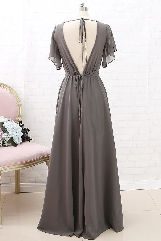 Woman wearing a flowing short-sleeve chiffon bridesmaid dress.