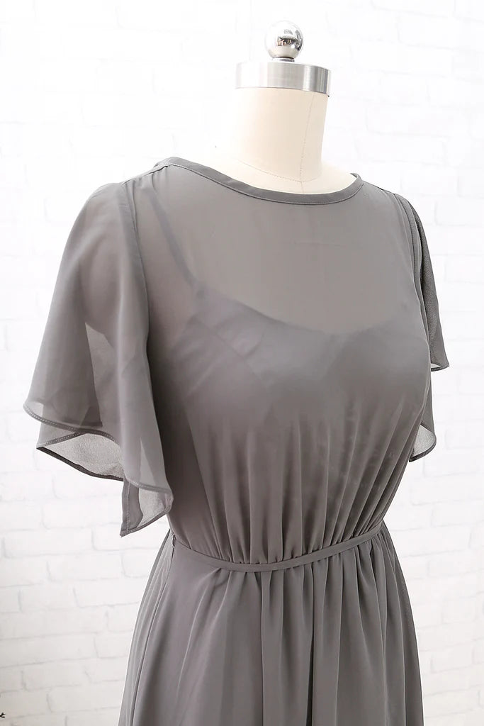 Side view of a woman in a long chiffon formal dress.