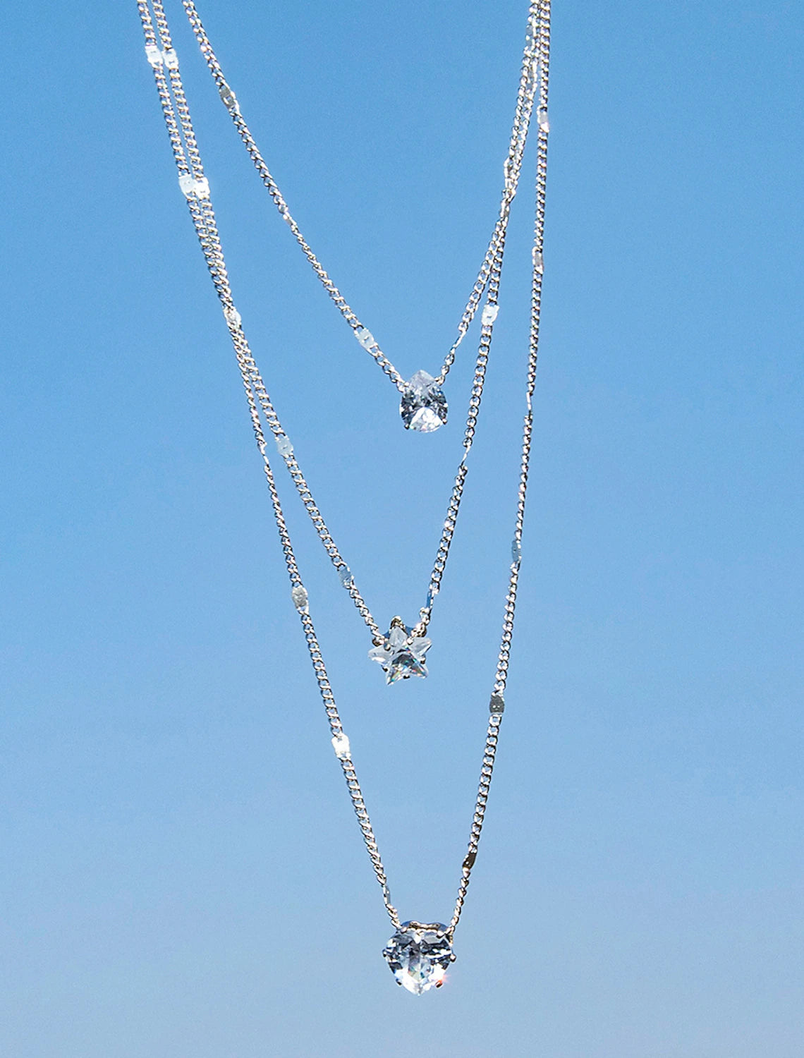 Close-up of a chrome geometric necklace with intricate design.