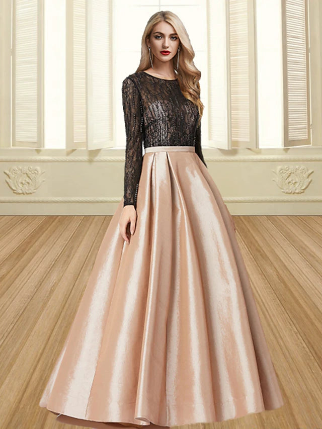 Model wearing an elegant color block ball gown with long sleeves and a jewel neck.