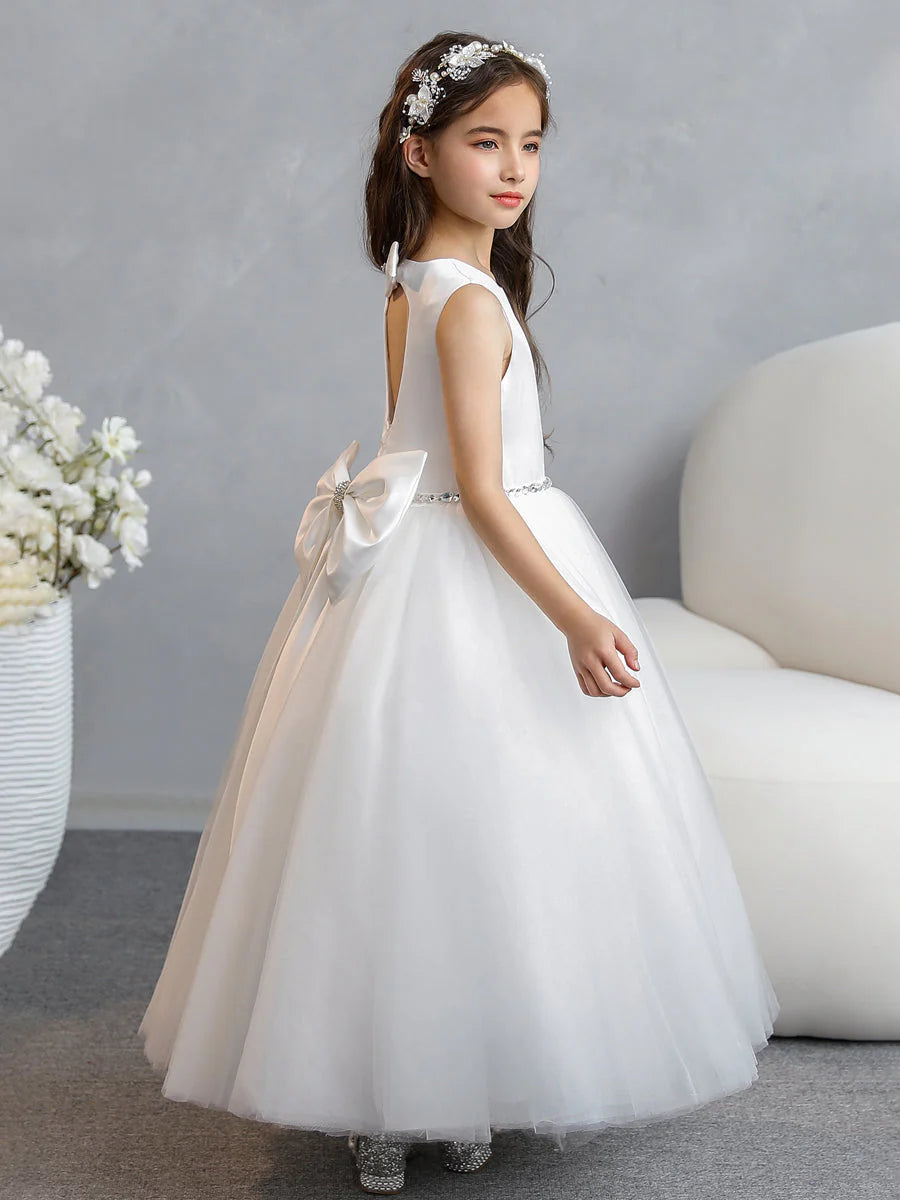 Side profile of the flowy blush pink tulle flower girl dress.