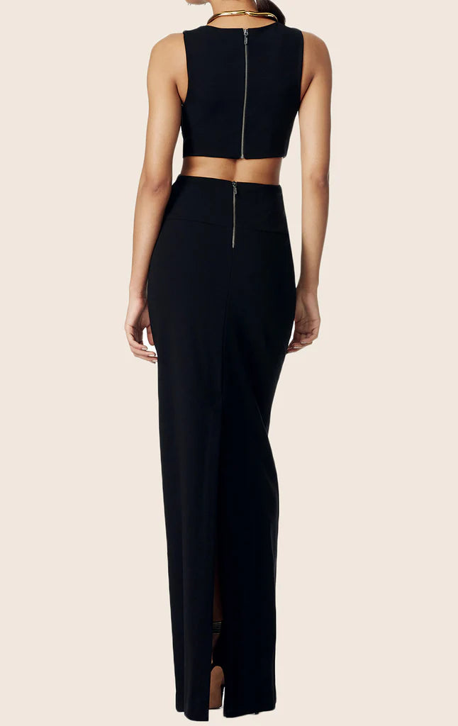 Woman showcasing the elegant black sleeveless formal maxi gown with a cut-out detail.