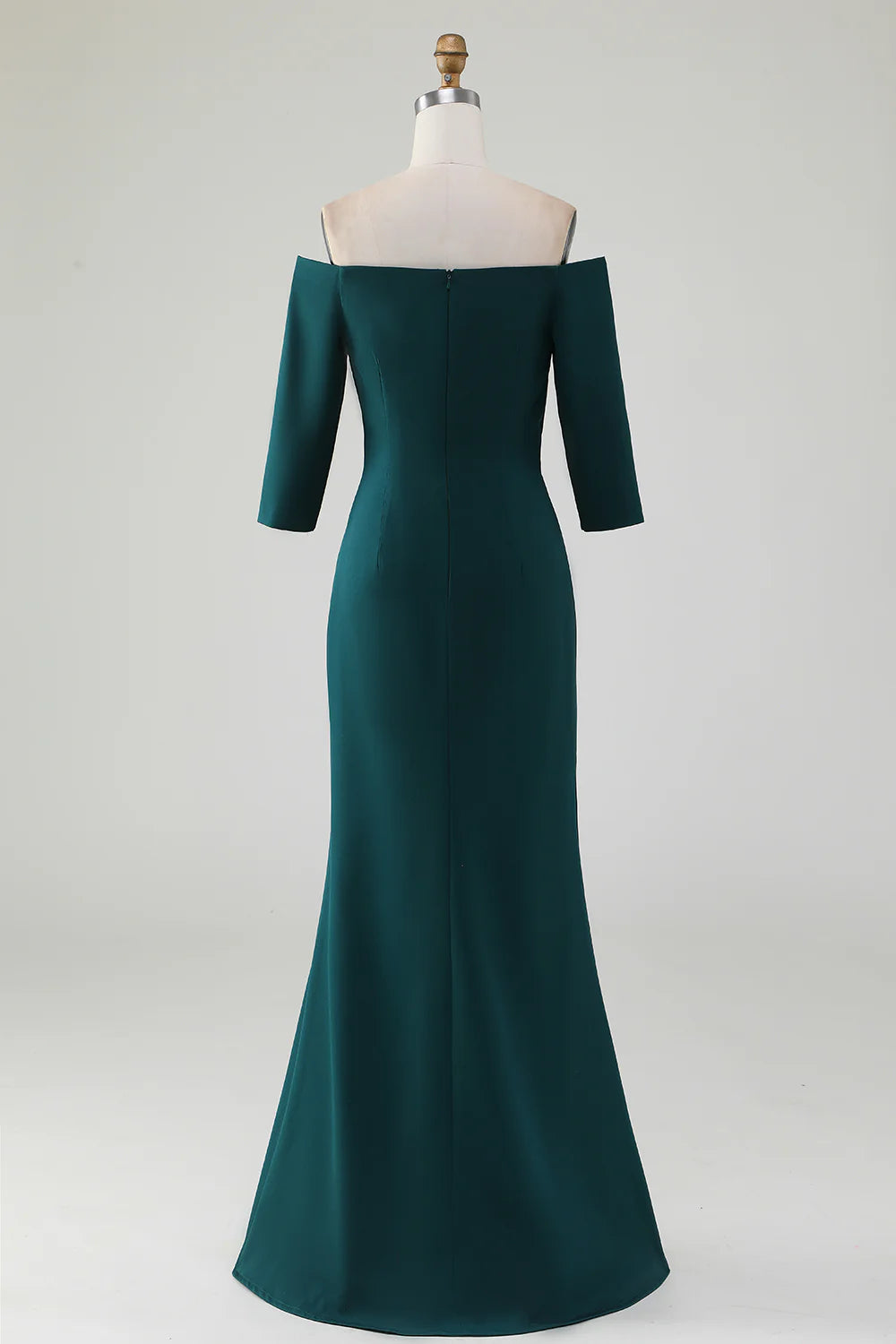 Model wearing a dark green mermaid off-shoulder dress, showcasing the back and ruffle details.