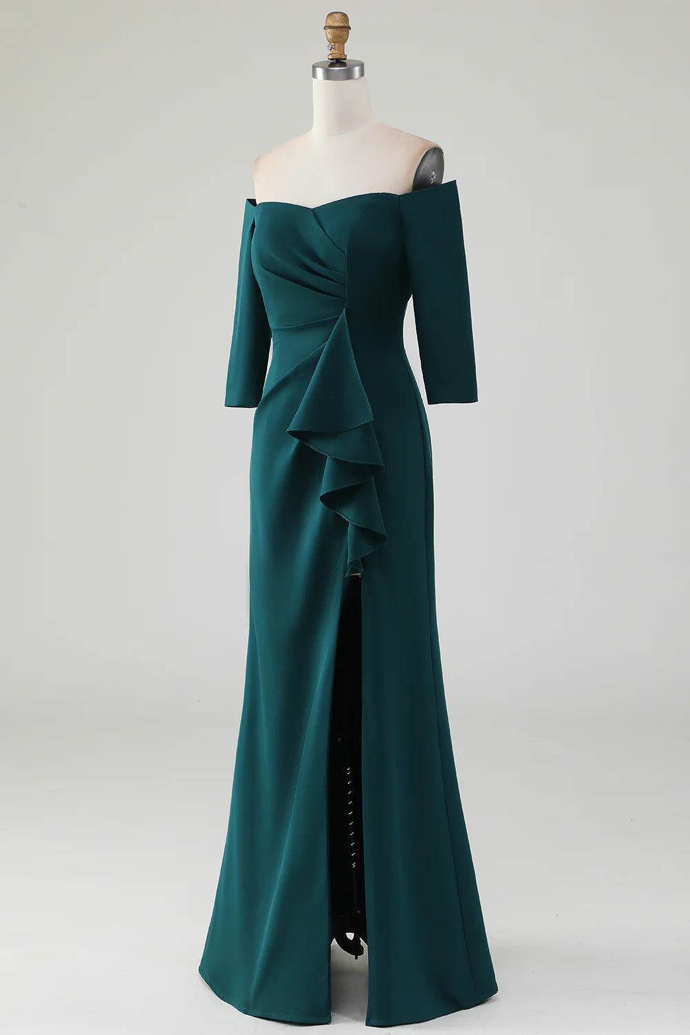 Side view of a dark green mermaid off-shoulder dress with ruffles, worn by a model.
