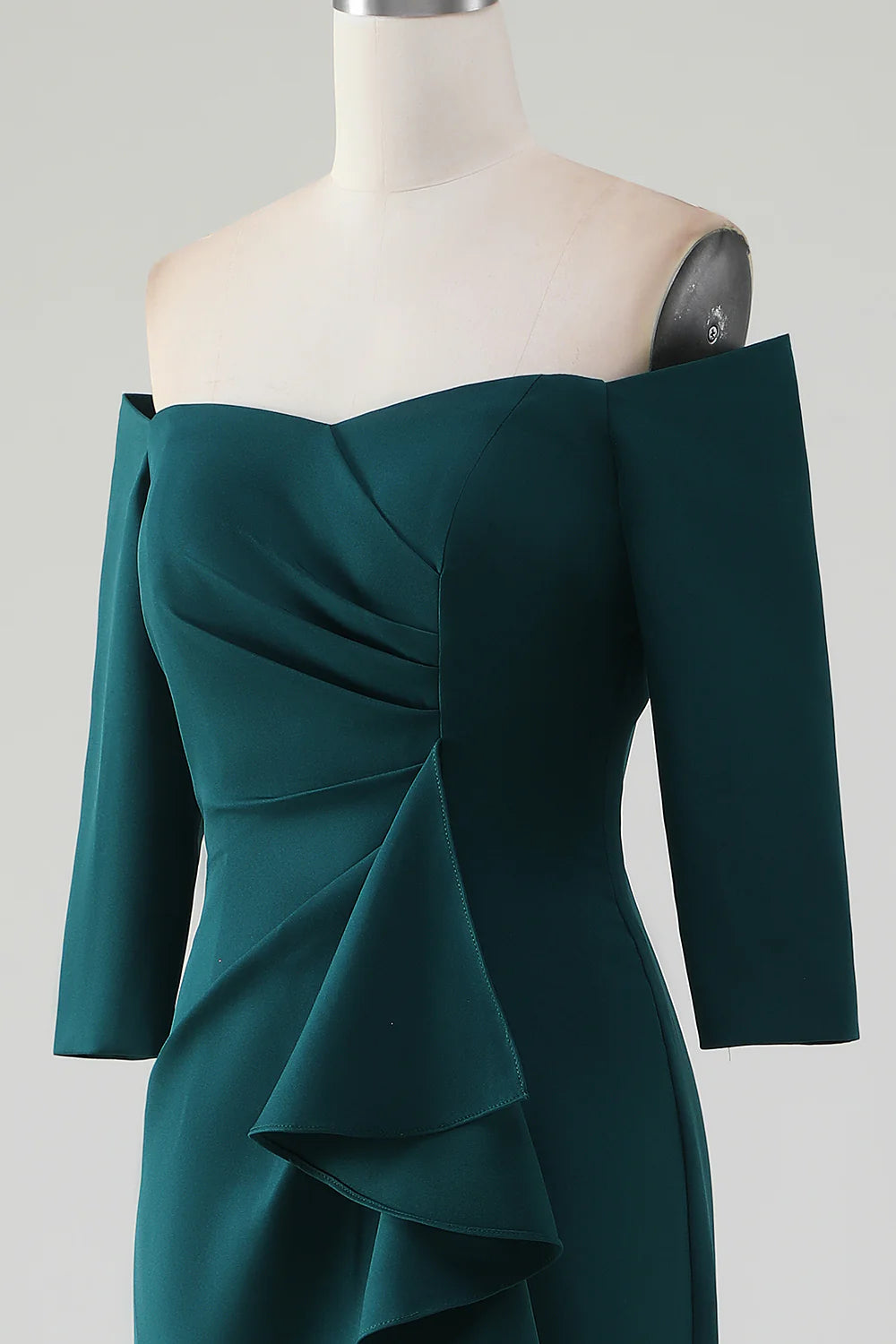 Close-up of the cascading ruffles and mermaid silhouette on a dark green dress.