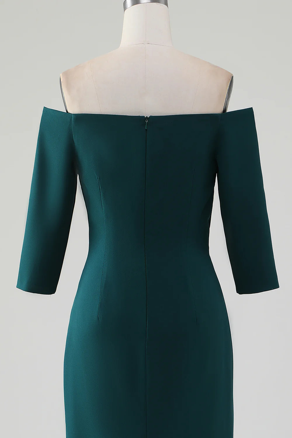 Model posing in a dark green off-shoulder mermaid dress, highlighting the elegant fit.
