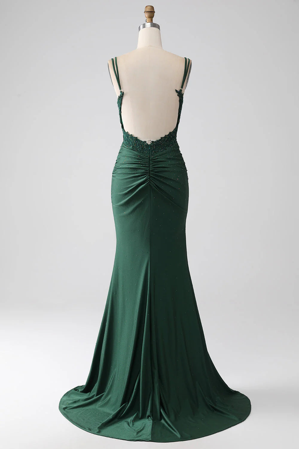 Back view of a dark green mermaid formal gown with a flowing train.