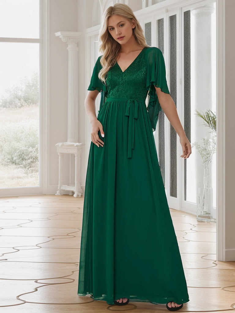 Model wearing a dark green deep V-neck lace bodice long flowy evening dress.