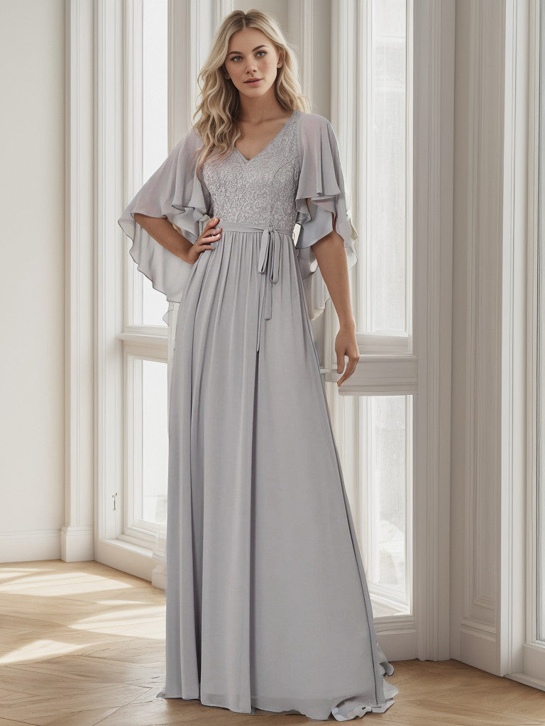 Model in a grey deep V-neck lace bodice long flowy evening dress.