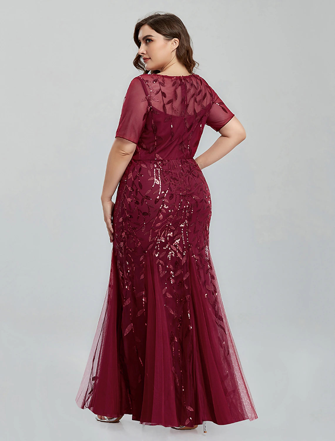 Close-up of the jewel neckline and short sleeves on the embroidered tulle evening dress.