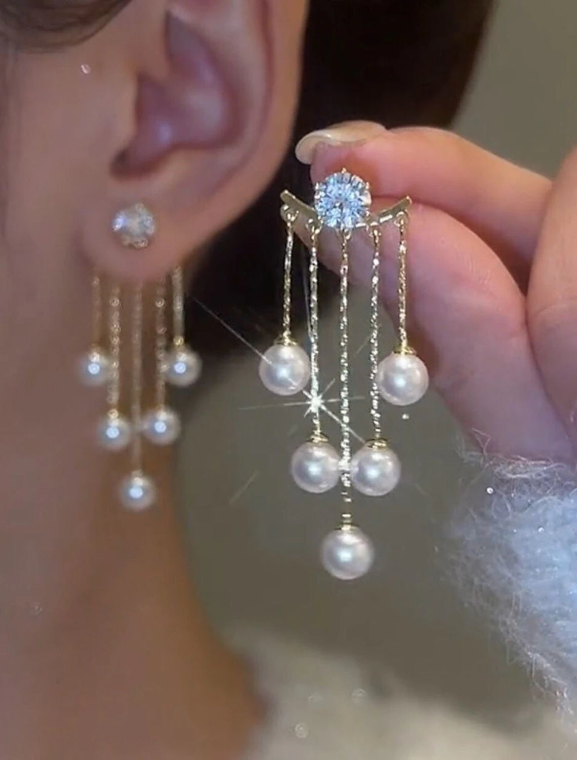 Side view of a white tassel fringe earring, showcasing its length and movement.