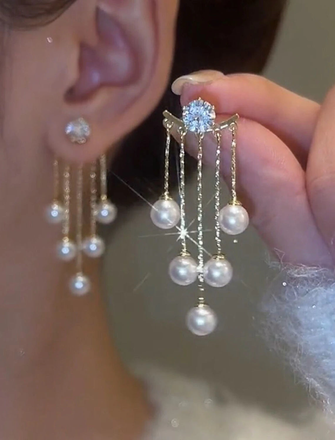Another angle of a white tassel fringe earring, emphasizing its delicate design.