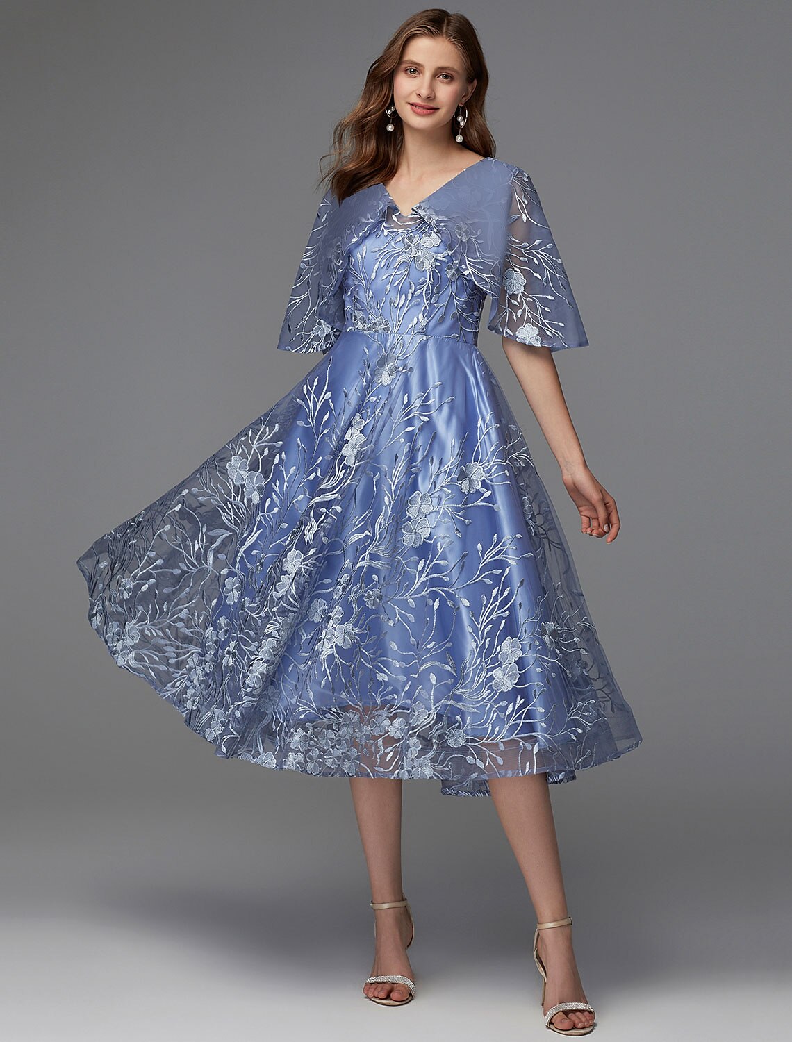 Woman wearing an elegant floral A-line tea length dress with V-neck.