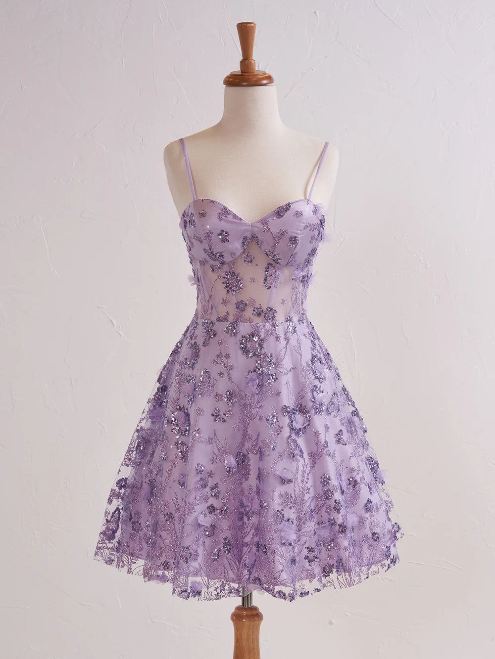 Model wearing a floral strapless sweetheart short cocktail dress.