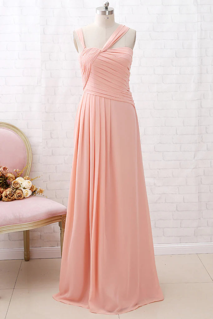 Woman wearing a full-length coral chiffon bridesmaid dress with spaghetti straps.
